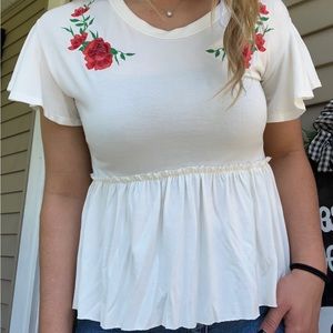 White blouse with red flowers.